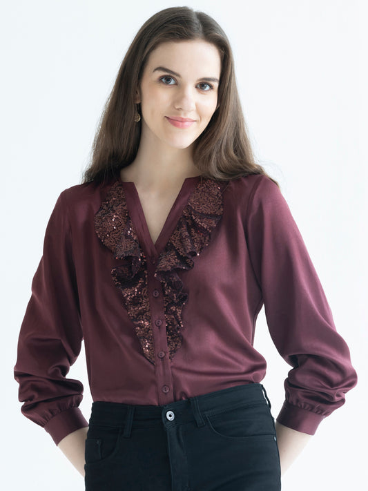 Model wearing brown satin Gramercy Shirt with V-neck full sleeves button down front and sequin frill detail at front