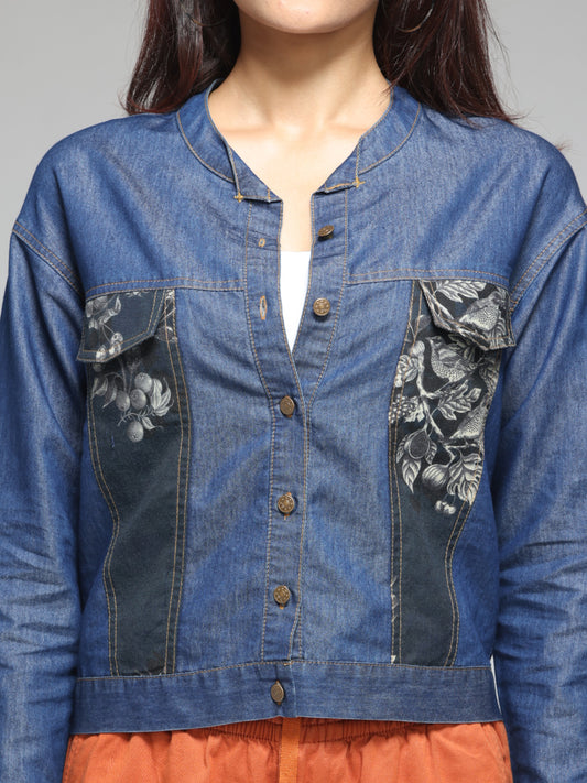 Close-up of patch print and round neckline on blue denim shirt, button front, soft lightweight denim