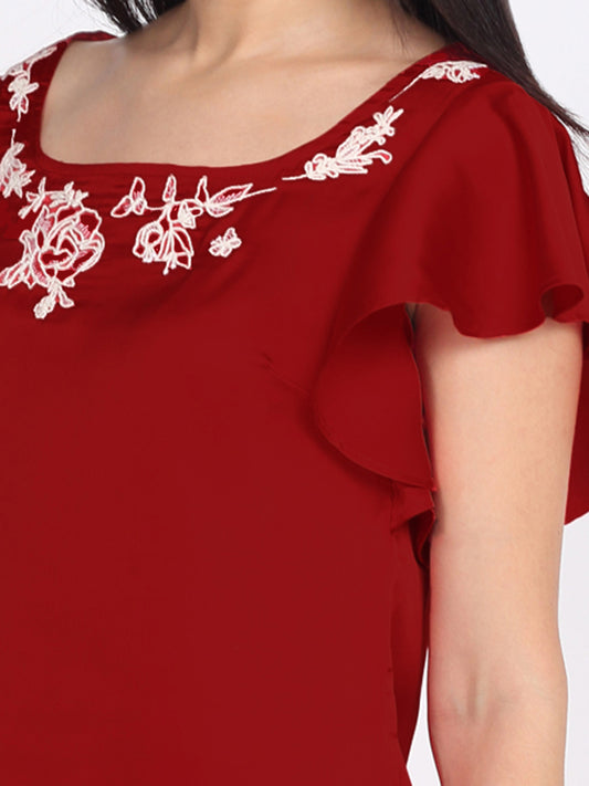 Close-up of square neckline and intricate floral embroidery with flared sleeve detail on maroon satin relaxed top