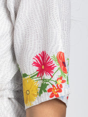 Close up of floral print and button detail on short sleeves of Adira Dress in breathable linen fabric