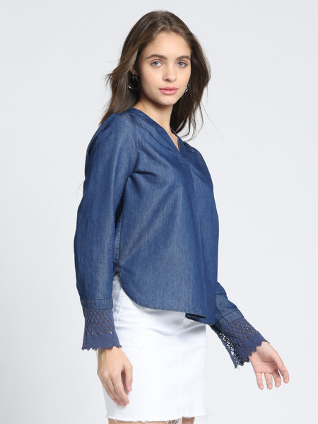 Side angle blue denim top, V-neck, relaxed fit, high-low hemline, full cuff sleeves, gathers at back yoke