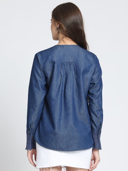 Back view blue denim top, gathers at yoke, high-low hemline, full cuff sleeves, relaxed fit