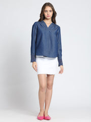Full body pose blue denim top, V-neck, pleats at front, long sleeves, high-low hem, relaxed fit