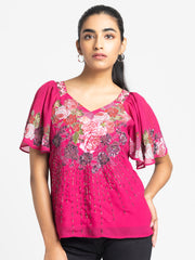 Model wearing pink Ambre Top with V-neck short flared sleeves hand embroidery on front and curved hem