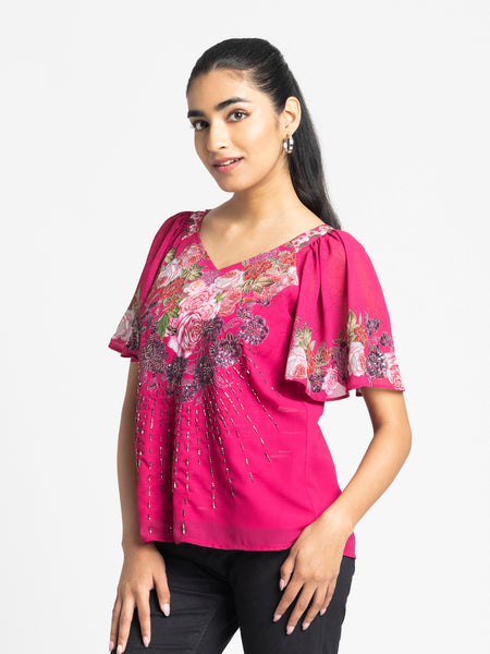 Relaxed side pose showing hand embroidery and floral print on soft pink georgette Ambre Top