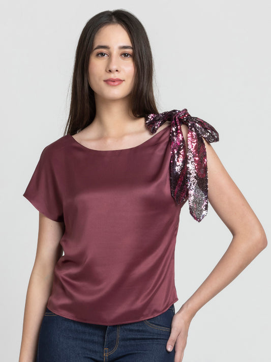 Model wearing brown Bali Top with boat neck short extended sleeves and printed sequin knot at shoulder