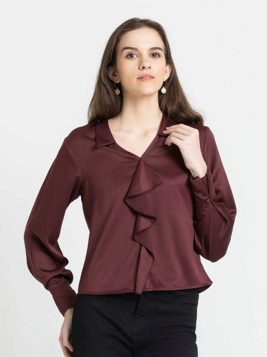 Model wearing brown Beckie Top with spread collar V-neck full cuff sleeves and ruffle detailing on front