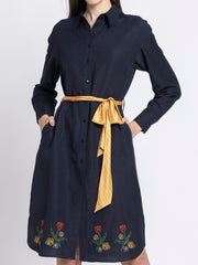 Close up of V-neck contrast collar and wrap panel on black floral satin dress showing three-quarter slit sleeves and pleated detail