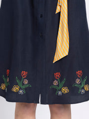 Close up of pleated detail and straight hem on black floral print satin dress in luxurious soft satin fabric