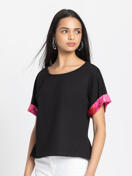 Left side view of black Laurina jersey t-shirt featuring drop shoulder sleeves with pink contrast detail