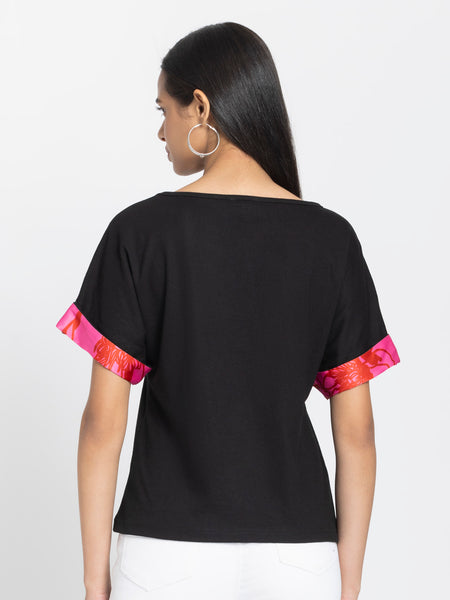 Back view of black Laurina knit t-shirt showing curved hem and relaxed fit silhouette with pink sleeve accents