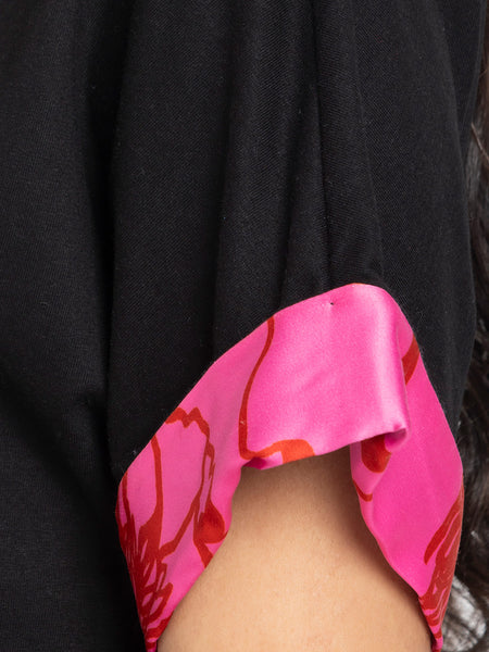 Close-up detail of pink printed sleeve accent on black Laurina t-shirt made from soft stretchy jersey fabric