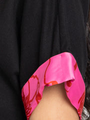 Close-up detail of pink printed sleeve accent on black Laurina t-shirt made from soft stretchy jersey fabric