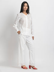 Model in motion, fitted sheath evening dress in champagne satin with sequin embroidered floral details and fringe sleeve