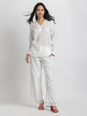 Model in motion, fitted sheath evening dress in champagne satin with sequin embroidered floral details and fringe sleeve