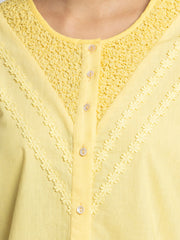 Close up of round neck embroidery on yoke and lace pintucks on front of yellow Ciara Shirt