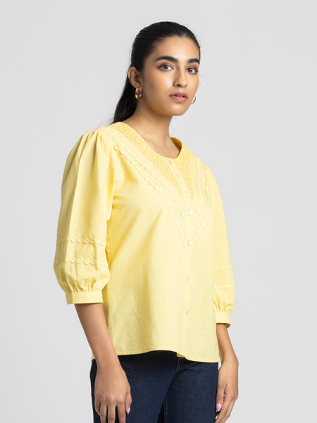 Model side pose in Ciara Shirt showcasing three-quarter sleeves rolled up detail and lace embroidery
