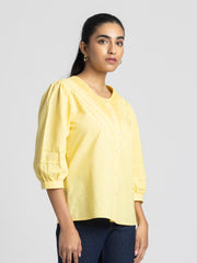 Model side pose in Ciara Shirt showcasing three-quarter sleeves rolled up detail and lace embroidery