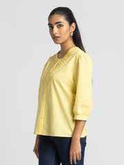 Side profile of yellow embroidered Ciara Shirt with curved hem button down front and breathable cotton fabric