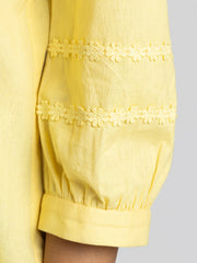 Close up of lace and pintucks embroidery on three-quarter sleeve cuff of yellow Ciara Shirt
