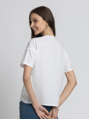 Rear view of white Cosette Shirt showing relaxed fit short sleeves Schiffli stitch embroidery and straight hem