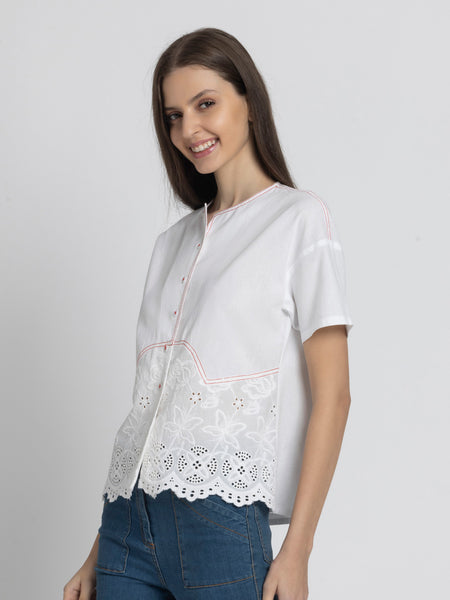 Side profile of model wearing Cosette Shirt with short sleeves Schiffli embroidery at hem and breathable cotton fabric