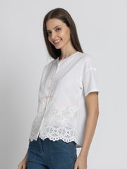 Side profile of model wearing Cosette Shirt with short sleeves Schiffli embroidery at hem and breathable cotton fabric