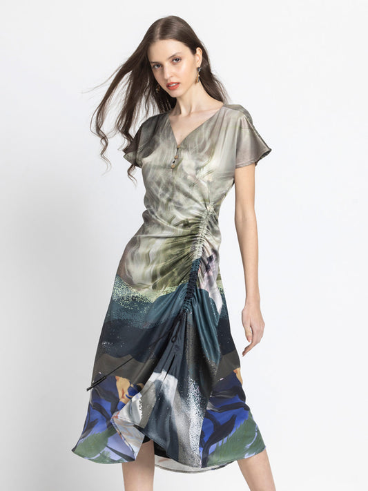 Model posing in beige printed Dorina Dress with V-neck drop shoulder sleeves and ruched side adjustable cord