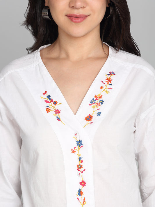 Close-up of v-neck with multicolor embroidery on white cotton top, front placket, and sleeve details, relaxed fit