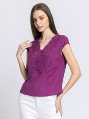 Model with hand near head wearing Elvira Top displaying overlap front V-neck and relaxed fit