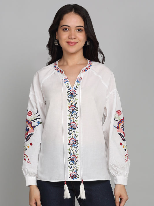 White cotton top with v-neckline, front tie up dori with tassels, floral embroidery on front and sleeves, full cuff sleeves, relaxed fit, straight hem, front view