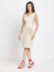Model walking in beige sheath party dress with fringes and floral sequin details, fitted silhouette