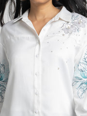Close up of floral print sequin embroidery and spread collar on white satin Georgia Shirt