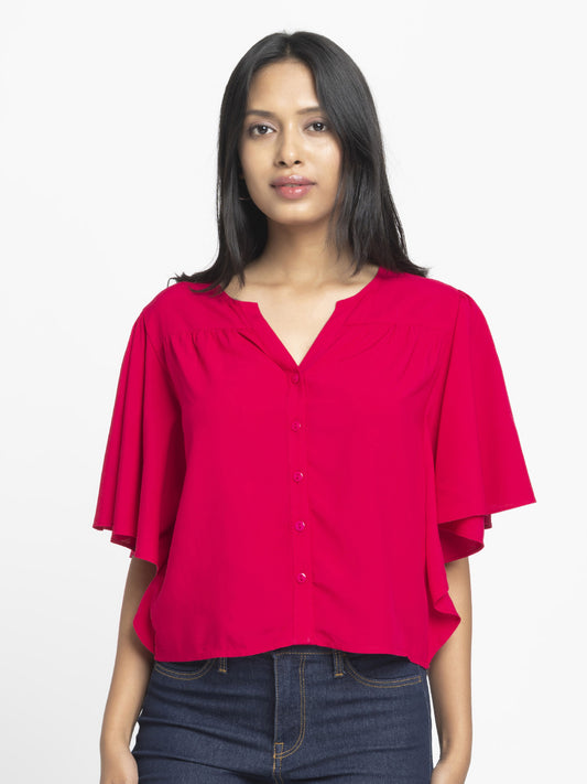 Model wearing fuchsia Jacqueline Shirt with V-neck short flared sleeves button down front gathers at yoke and curved hem