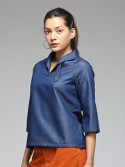 Side angle blue denim top featuring V-neckline, belt fastening, slit three-quarter sleeve, relaxed curved hem