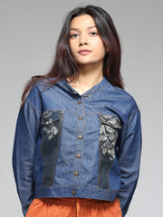 Button and print patch close-up on blue denim shirt, round neck, straight hem, relaxed fit