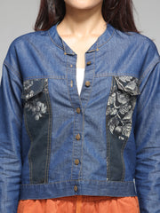 Close-up of patch print and round neckline on blue denim shirt, button front, soft lightweight denim