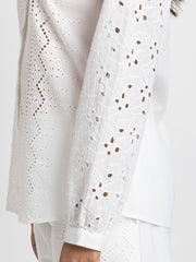 Extreme close-up, textured fringe beading and sequin embroidery detail on luminous beige satin sheath party dress