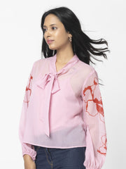 Model wearing Maine Top with tie up neck full sleeves and pink floral print cami visible under sheer chiffon