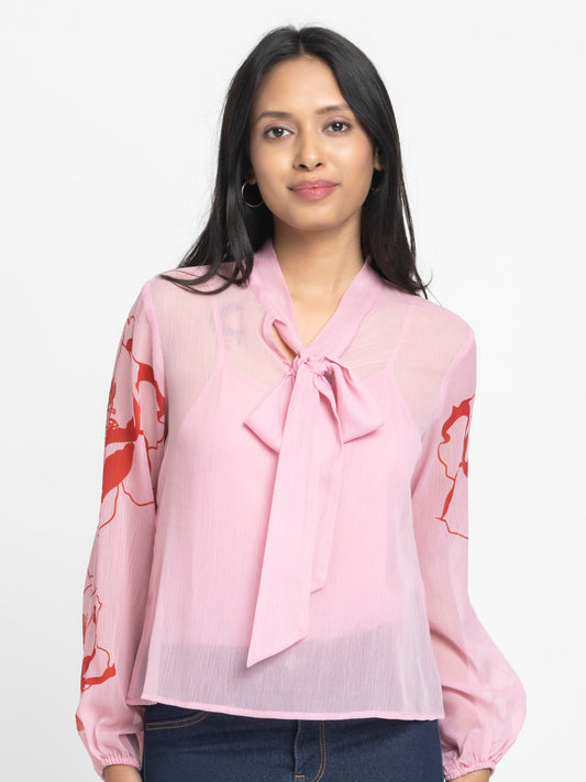Model wearing pink printed Maine Top with tie up neck full elasticated sleeves and relaxed fit curved hem