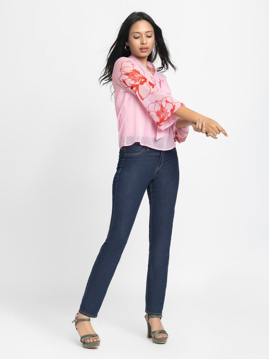 Model playfully posing in pink chiffon Maine Top with cami highlighting soft curved hem and light floral print