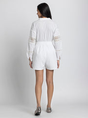 Rear view of model wearing Maleah Playsuit revealing long sleeves straight hem and lace patch detail