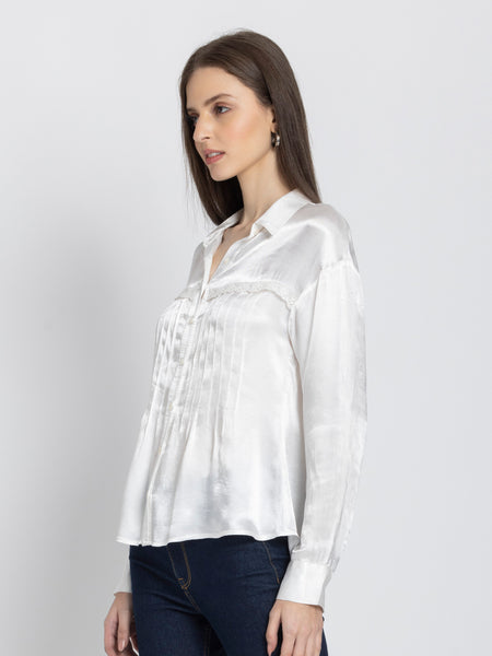 Side profile of white Minnie Shirt showing lace and pintuck front detail button closure and flowy satin material