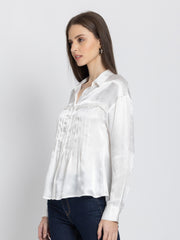 Side profile of white Minnie Shirt showing lace and pintuck front detail button closure and flowy satin material