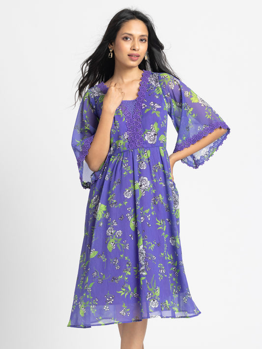 Model wearing purple floral print Mucia Dress with V-neck short bell sleeves and crochet embroidery neckline