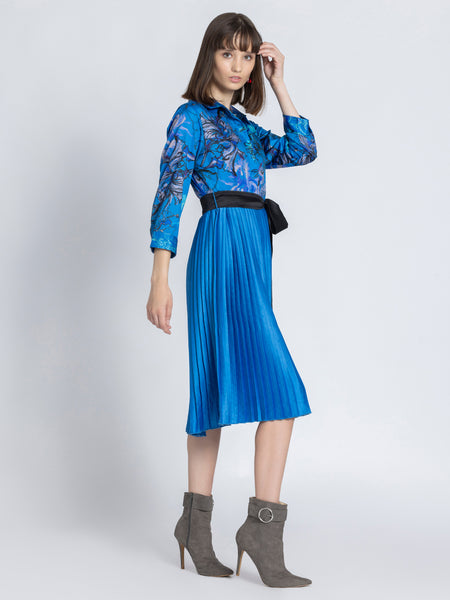 Model in Olga Dress three quarter front pose showing floral print pleated skirt and belt