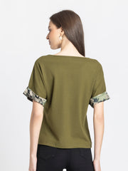 Back view of olive green Riya knit t-shirt showing curved hem and relaxed fit silhouette with printed sleeve details