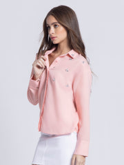Side view of peach Tamara embellished shirt showing relaxed fit silhouette and curved hem design details