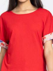 Detail view of red Thea jersey t-shirt showing soft fabric texture and scoop neckline construction quality