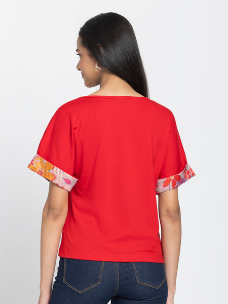 Back view of red Thea knit t-shirt showing curved hem and relaxed fit silhouette with printed sleeve details